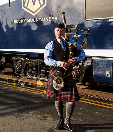 Bagpiper plays in front of Rocky Mountaineer