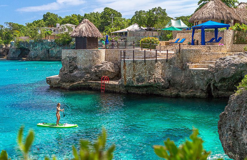 Paddleboarding the clear cerulean waters of Pristine Cove near the Rockhouse and The Cliff