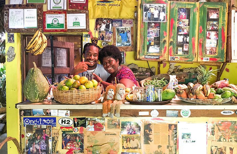 Theresa, owner of the Just Natural Cafe, jokes with local reggae artist Frezi at her popular Rastafarian eatery set in an all natural garden just around the corner from The Cliff