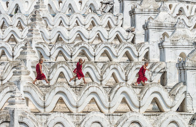 Three young monk are running and jumping on the Mya Thein Tan Pagoda at bagan, Mandalay