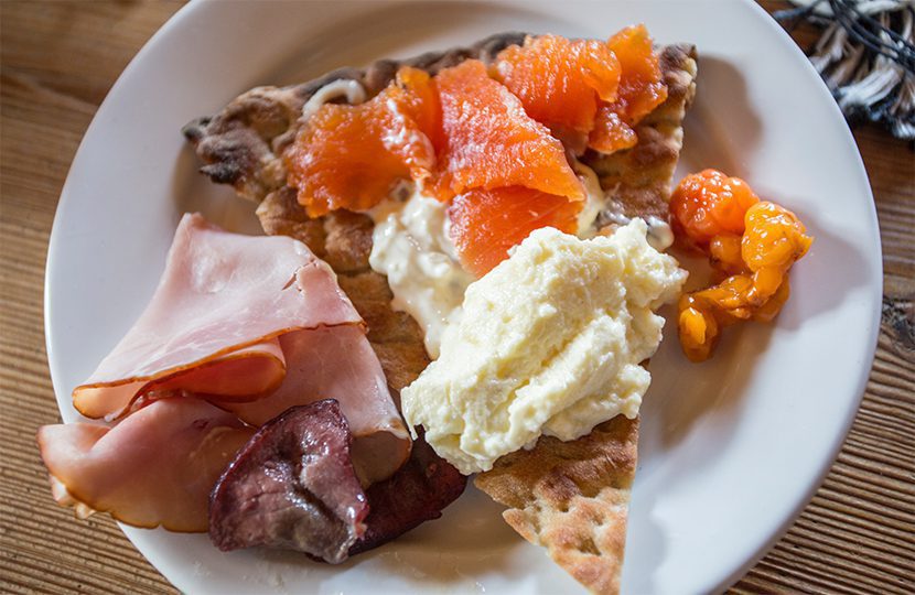 Breakfasts include crisp bread, paired with soft-cooked eggs, preserved trout caught from the lake, local meats and preserved cloudberries - 