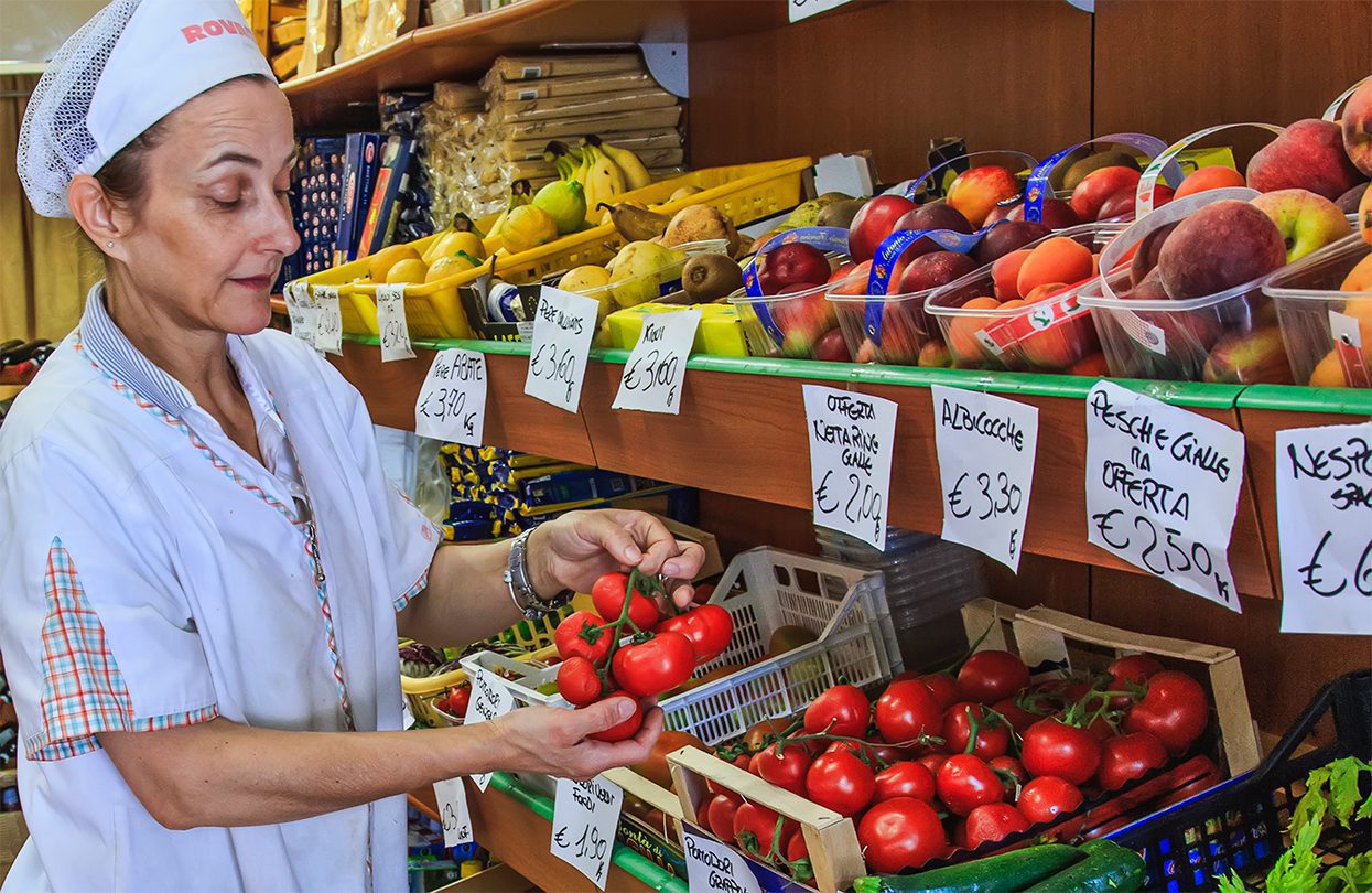 A shopkeeper demonstrating the plumpness of her tomatoes - 