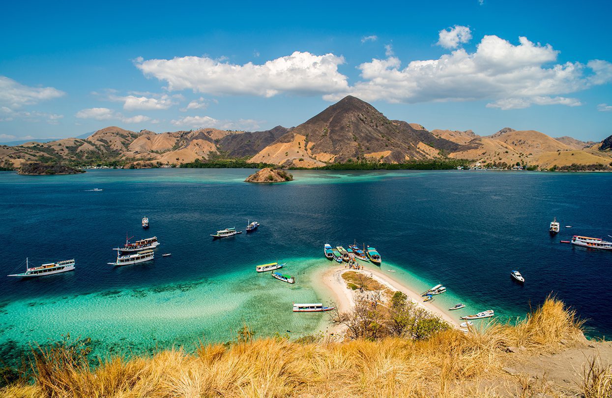 Tourist boats at the coast of Kelor Island by Prawat Thananithaporn