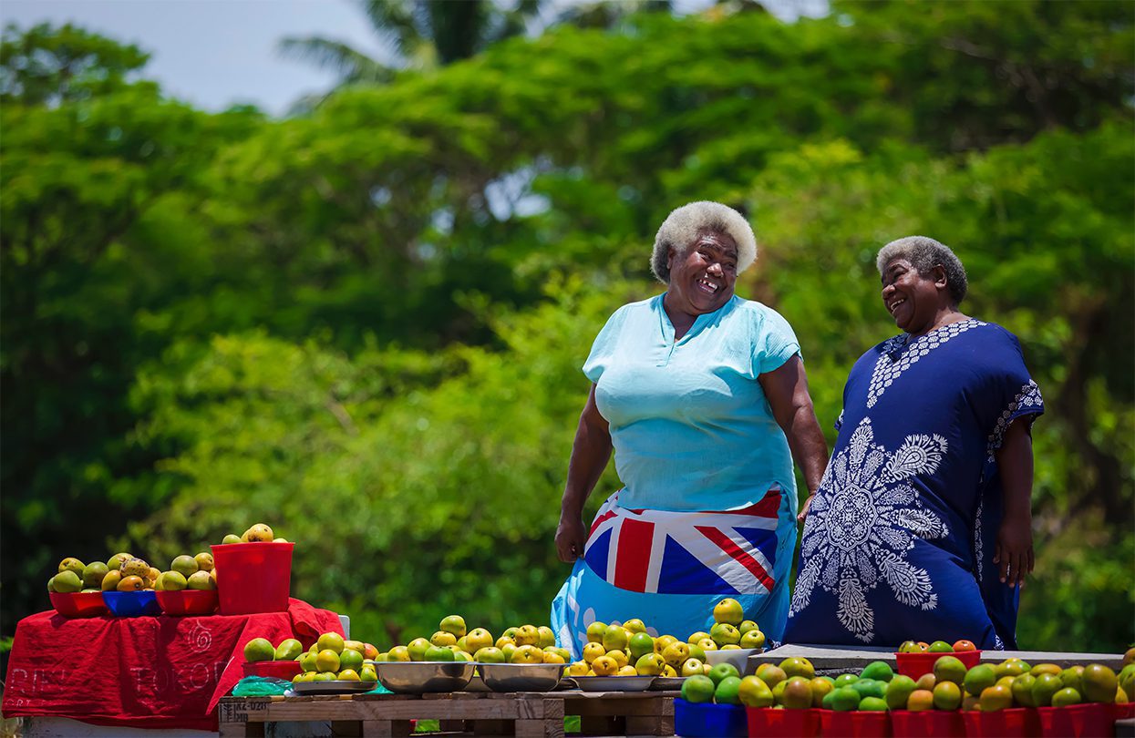 Local Fijian women selling mangoes at a roadside stall, image by Tourism Fiji