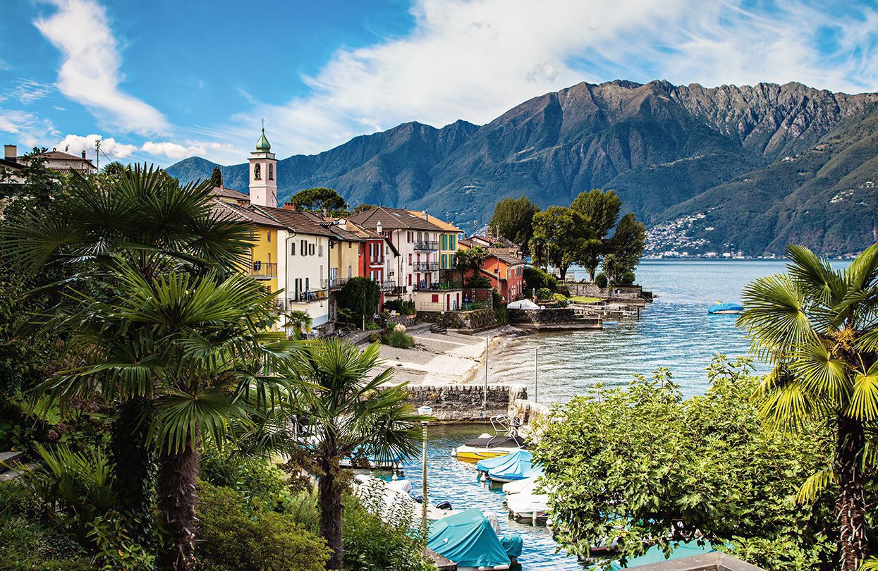 Small harbor with colourful row of houses on Lake Maggiore, Switzerland Tourism - Jan Geerk