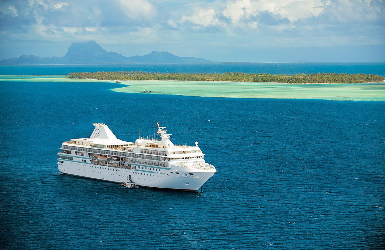 Paul Gauguin sailing in French Polynesia in the Society Islands (with Bora Bora in the background)