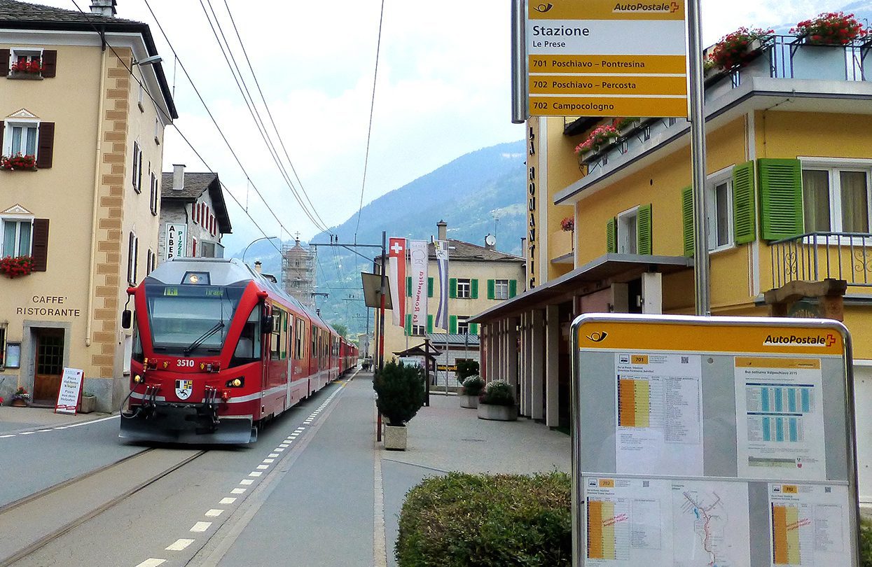 The Bernina Express going down the street in Le Prese, Valposchiavo