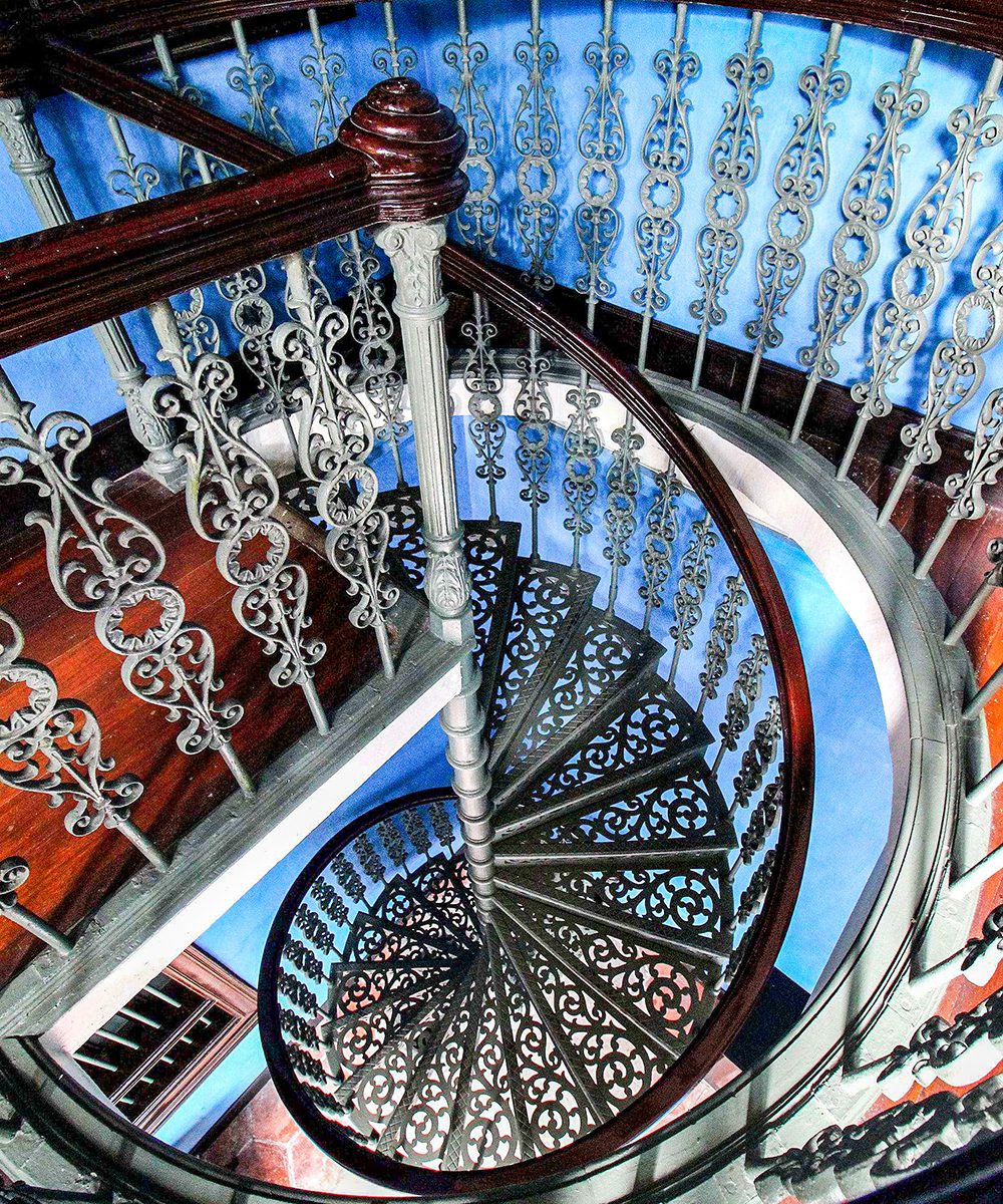 Spiral metallic staircase with ornate steps add a sense of whimsy in The Blue Mansion
