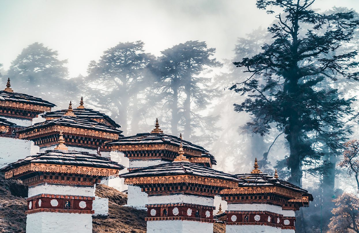 A foggy morning in the kingdom of Bhutan, memorial stupa at the highest point of Dochu-la pass, by Ilya Kuznetsoff