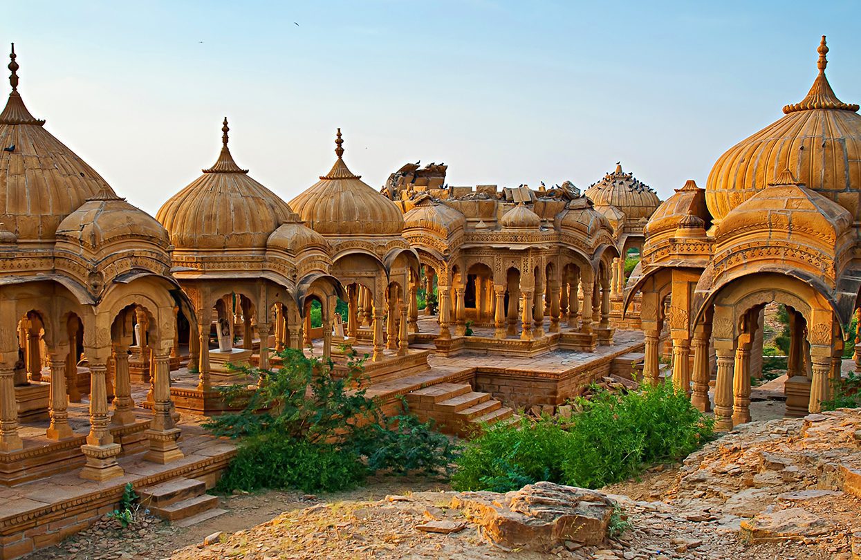 The royal cenotaphs of historic rulers, also known as Jaisalmer Chhatris, at Bada Bagh in Jaisalmer made of yellow sandstone By Olena Tur