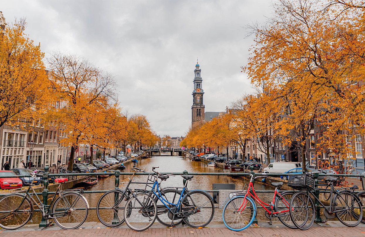 Autumn cityscape in Amsterdam with canal and bridge and the Westerkerk church tower, image by Wut_Moppie