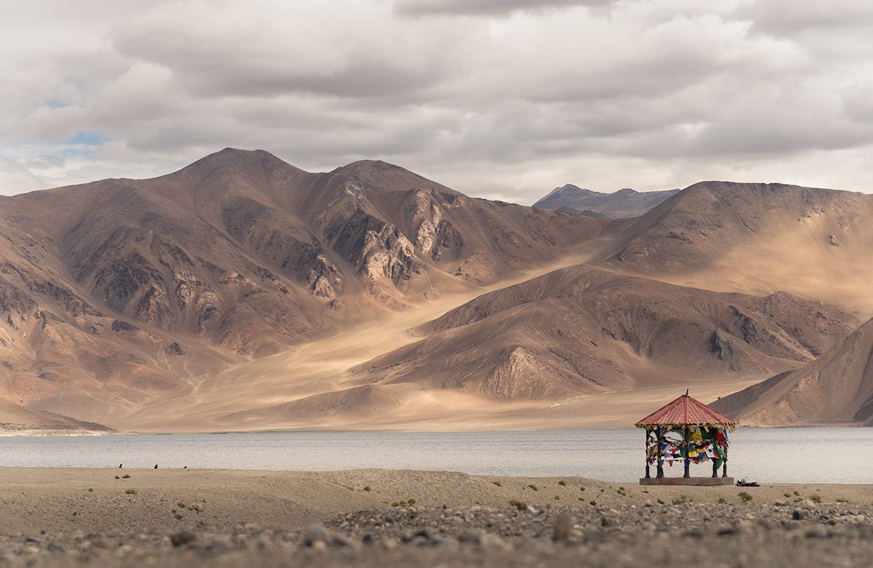 Red pavilion over Pangong Lake and Mountains. It is huge and highest lake and cloudy sky background in Ladakh, Image by Nataporn Sesthapaisarn