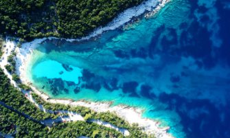 Aerial drone photo of tropical Caribbean bay with white sand beach and beautiful turquoise and sapphire clear sea, image by Aerial-motion