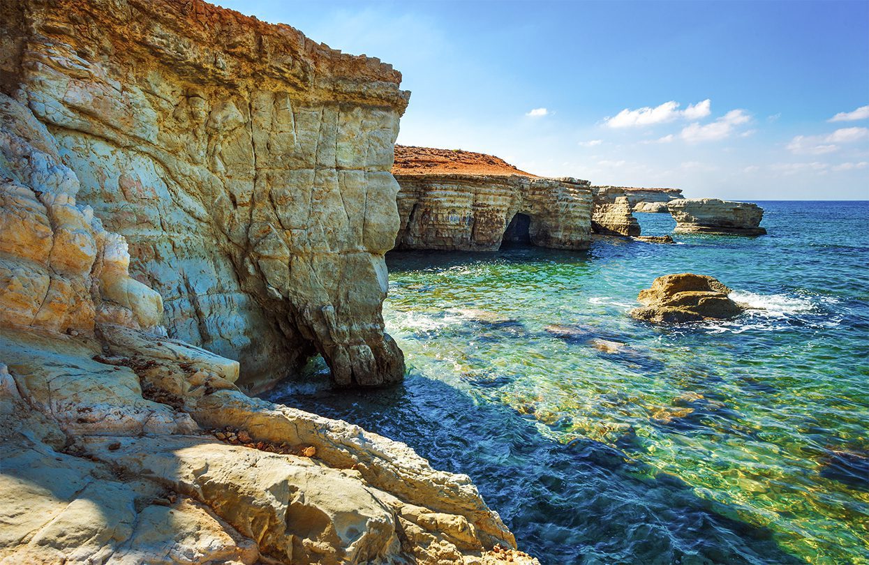 Crystal-blue waters at the Sea Caves on the Coral Bay coastline, by Roman Evgenev