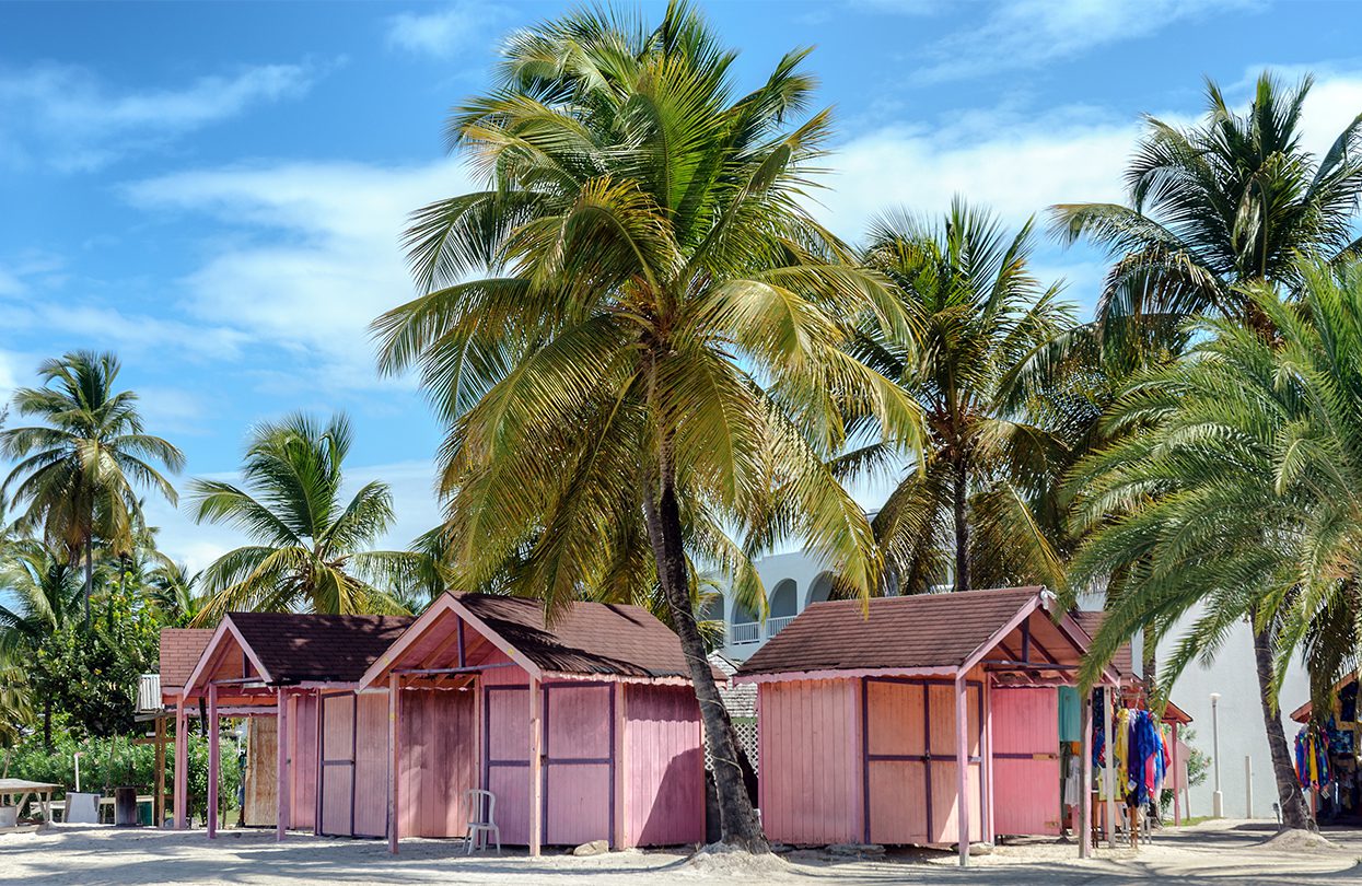 Pink huts and palm trees representing just a few of the vibrant colors on display in Antigua, which is one of the Twin Islands alongside nearby Barbuda, image by Lux Blue