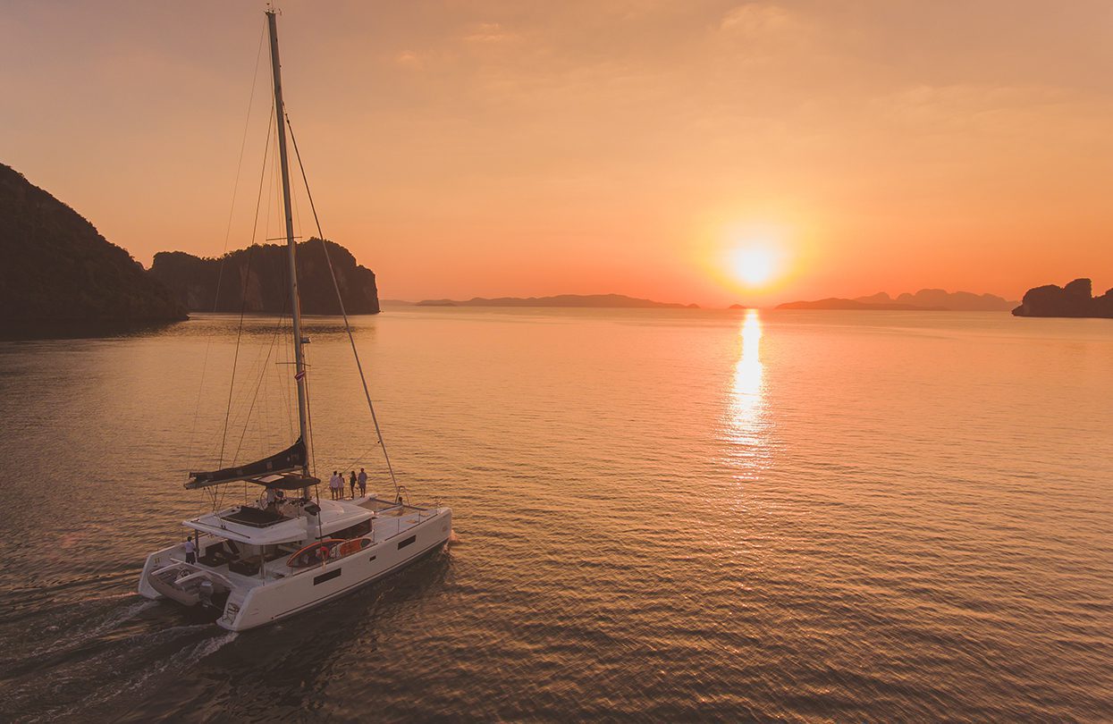 The Blue Moon catamaran sails into the dramatic sunset of Phuket, Photo - Wan Tse, Simpson Yacht Charter