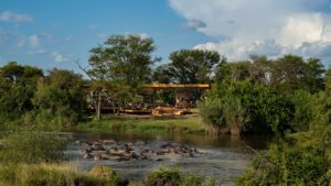 Tanzania Grumeti Serengeti River Lodge exterior with hippo pod Tanzania Grumeti Serengeti River Lodge exterior with hippo pod