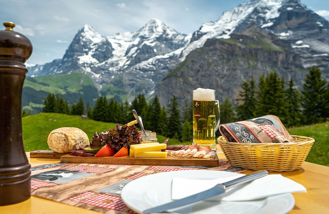 Enjoying a selection of dry-cured meats and regional cheese specialities at Allmendhubel Panorama Restaurant, image by Switzerland Tourism