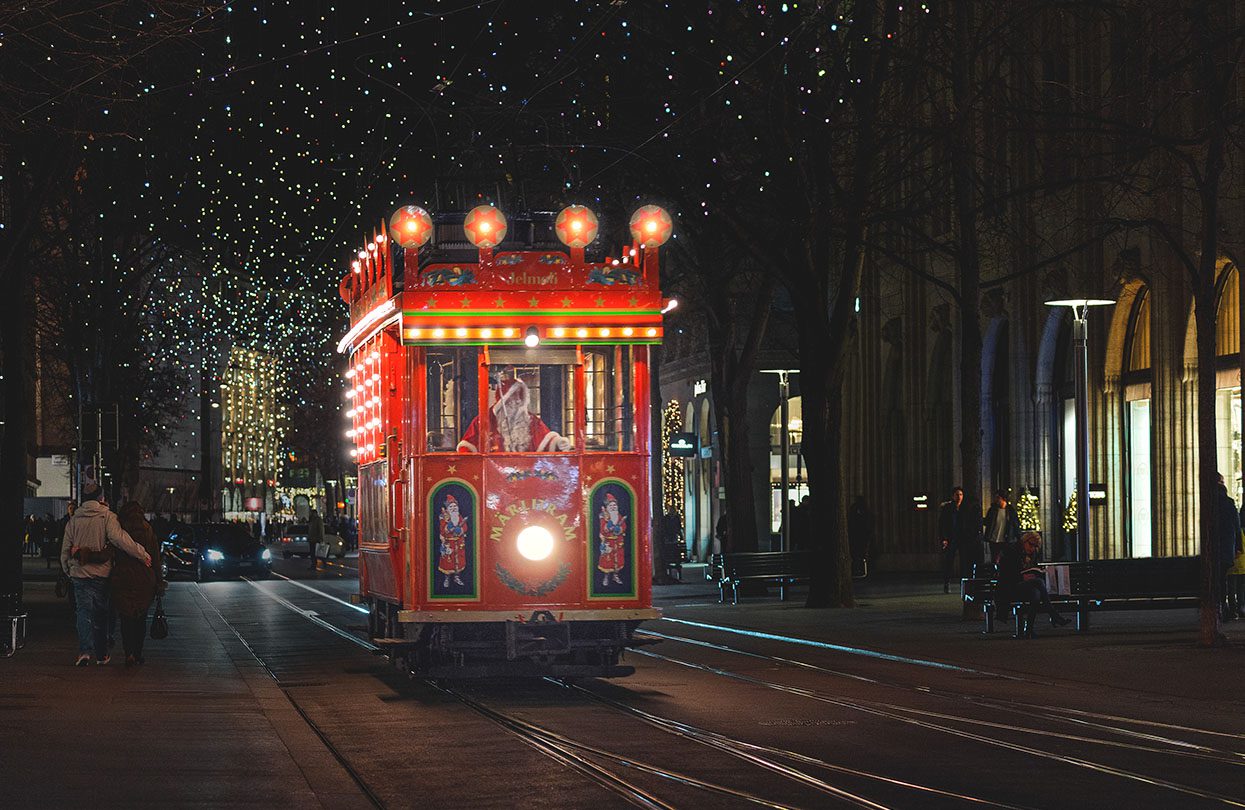 Santa driving through Zurich on his brightly decorated red Märlitram, image by Mario Modena, Zürich Tourism