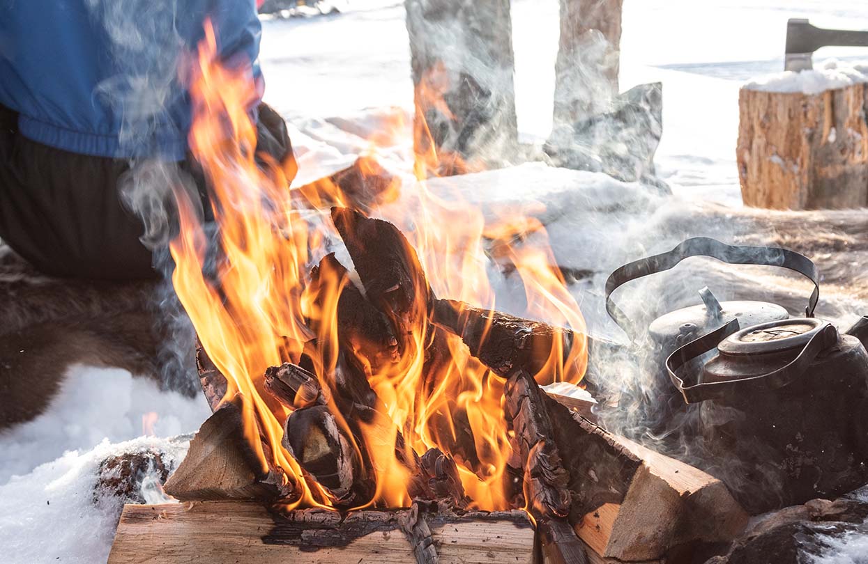 Campfire with kettle in the snow in Finland, image by Nancy Pauwels, Shutterstock