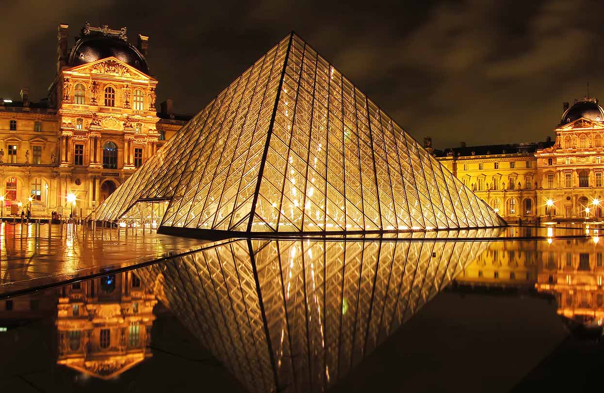 Louvre museum and Pyramid at night, image by Javen, shutterstock