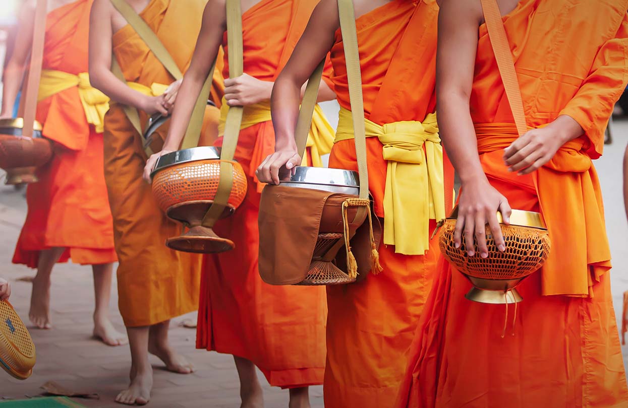 Monks carrying their alms bowls for going on almsround in early morning, image by Tanes Ngamsom, Shutterstock