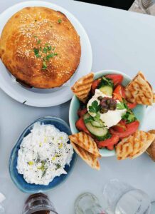 Grilled pita bread, tzatziki greek yoghurt with garlic, greek salad, baked Cheese at Sifnos Image by MM_vision, Shutterstock