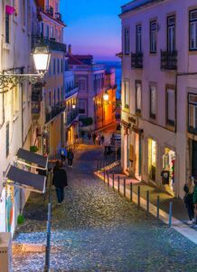 View of the Tagus River at evening sunset from a hillside cobblestone street in the medieval Alfama district of Lisbon, image by Kirk Fisher, Shutterstock