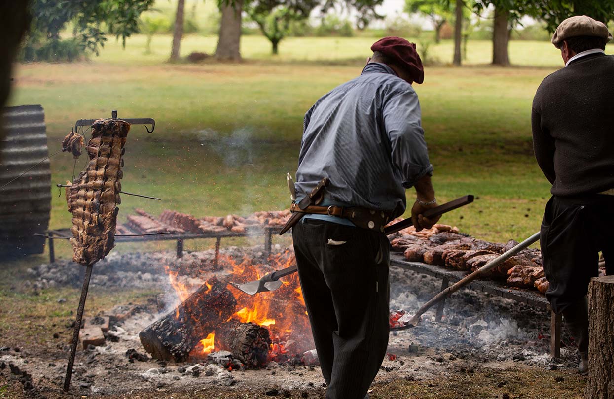 A gaucho getting dinner started on a asado, Image by Maria Elisa Rol, Shutterstock